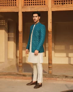 very handsome khushal khan wearing white kurta trouser and zinc color princecoat and standing
